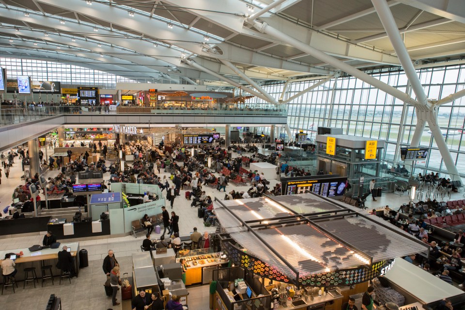 a busy airport with a sign that says ' departures ' on it