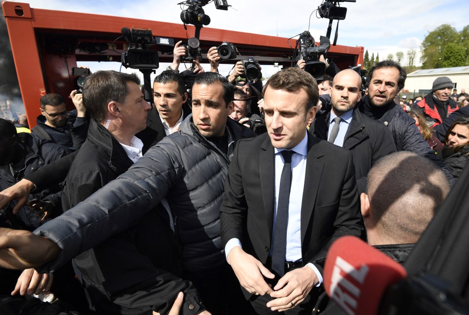 French president Emmanuel Macron being guided by security