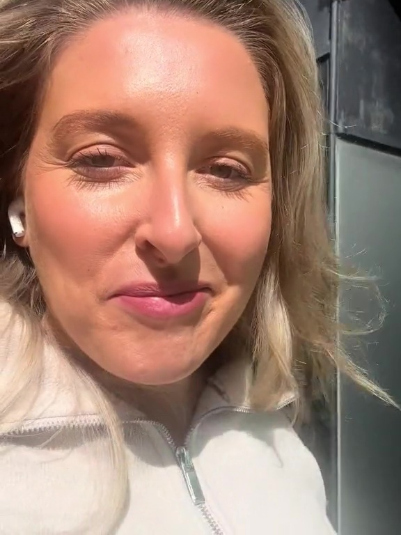 a close up of a woman wearing headphones and a white jacket .