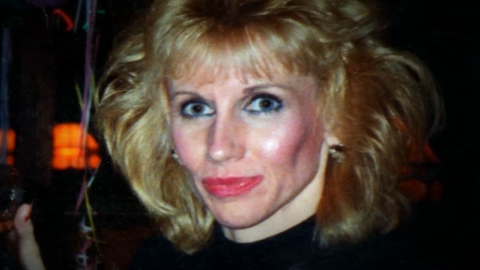 a woman with blonde hair and red lips looks at the camera