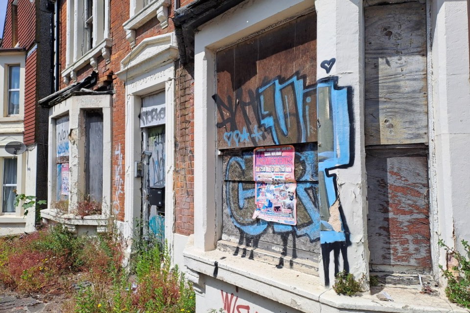 The dilapidating building is covered in unsightly graffiti