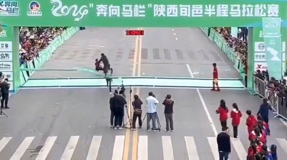 a group of people watching a race with a sign that says ' zong ' on it