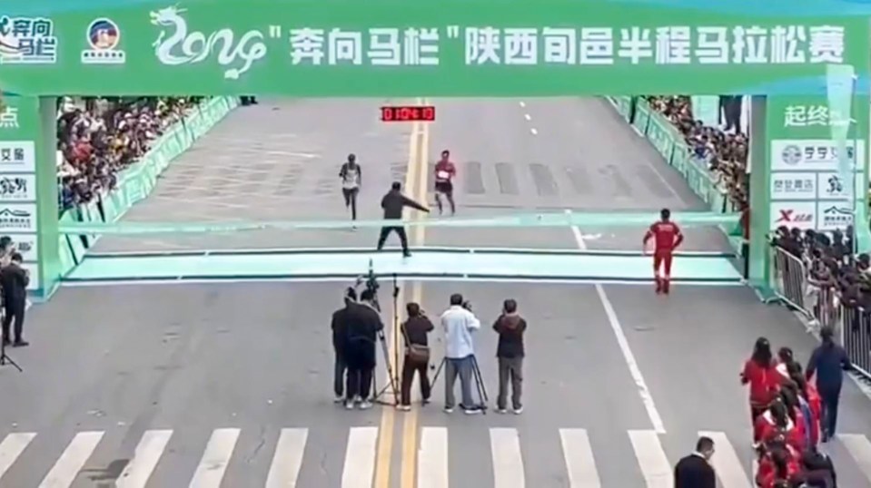 a runner crosses the finish line of a race with a banner that says ' 2016 ' on it