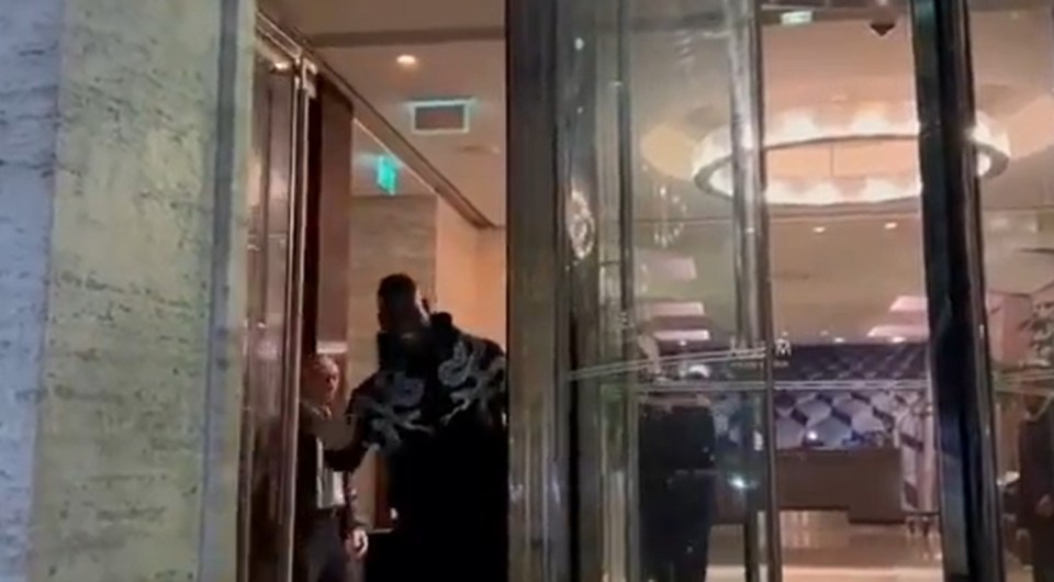 a man is standing in front of a glass door in a building .