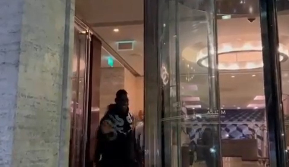 a man is walking through a glass door in a building .