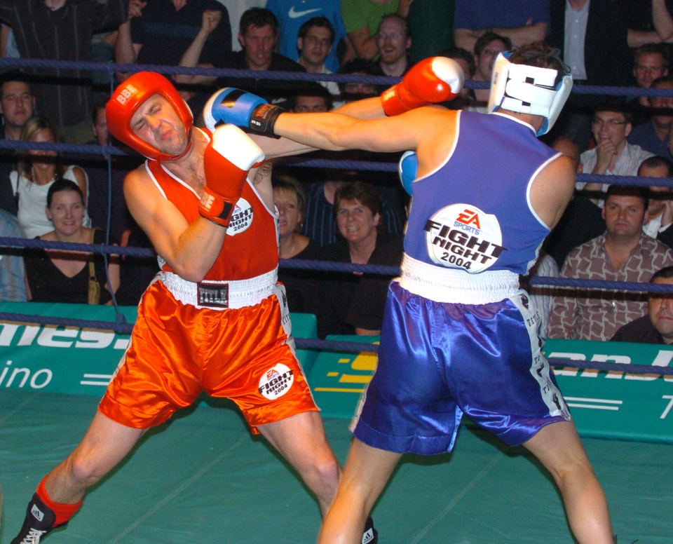 two boxers in a ring with one wearing a blue shirt that says fight night