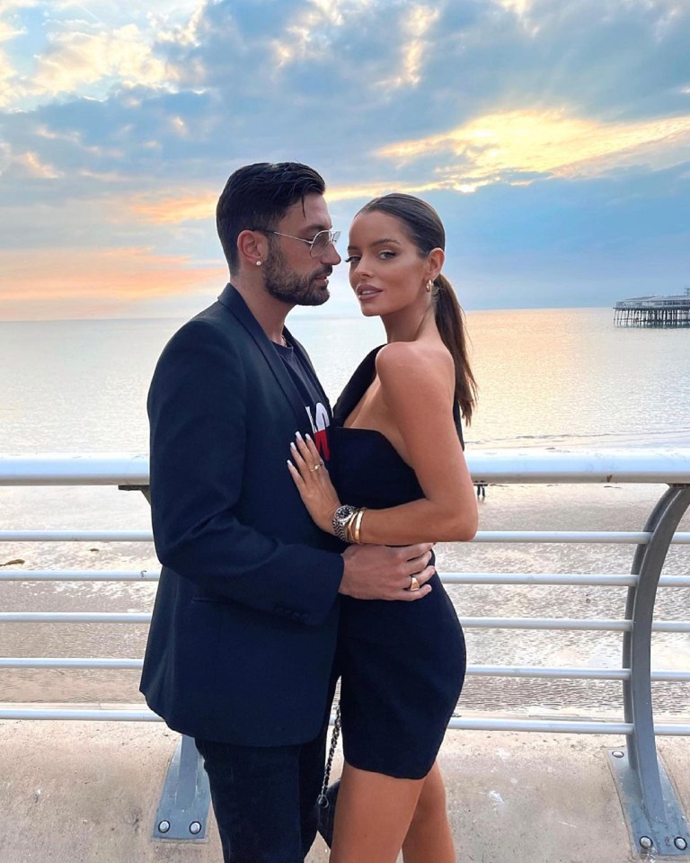 a man in a suit and a woman in a black dress pose for a picture