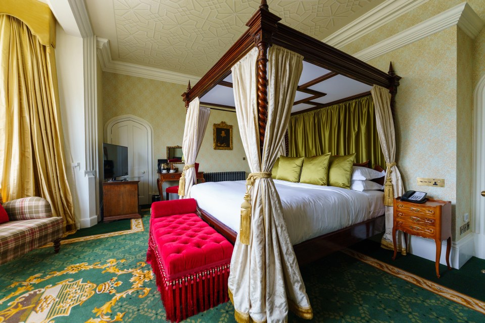 a bedroom with a canopy bed and a red bench