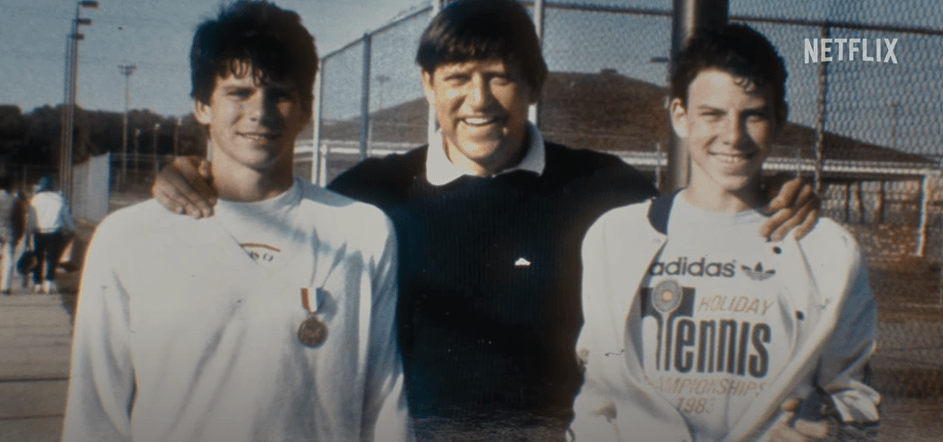 three men posing for a picture with one wearing an adidas tennis shirt