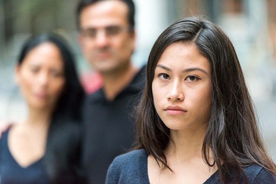 a woman stands in front of a man and a woman