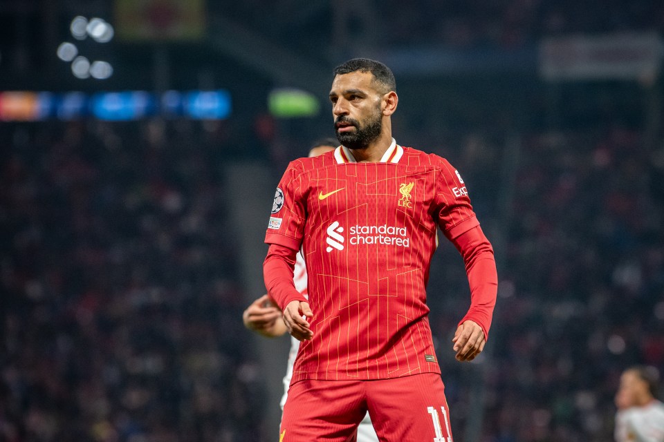 a soccer player wearing a red jersey that says standard chartered