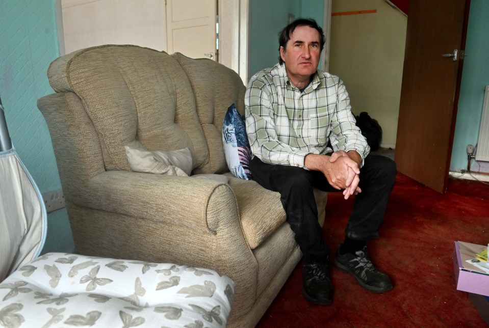 a man sits in a chair with his hands folded