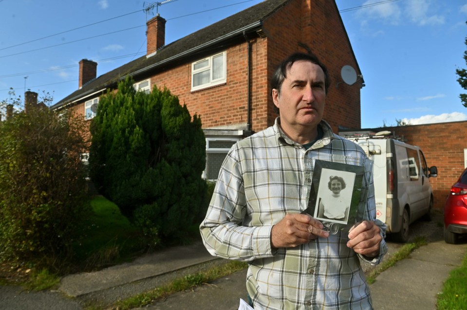 a man in a plaid shirt is holding a picture of a woman