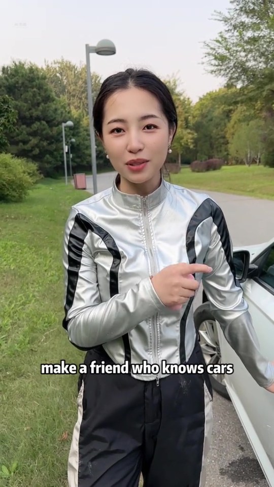 a woman is standing next to a car and says make a friend who knows cars