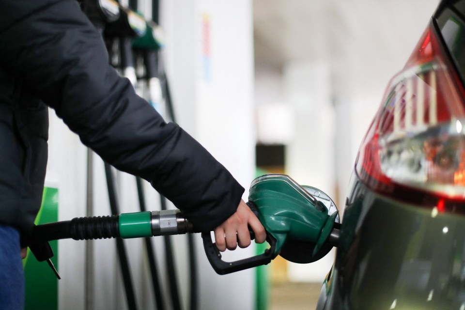 a person is pumping gas into a car at a gas station