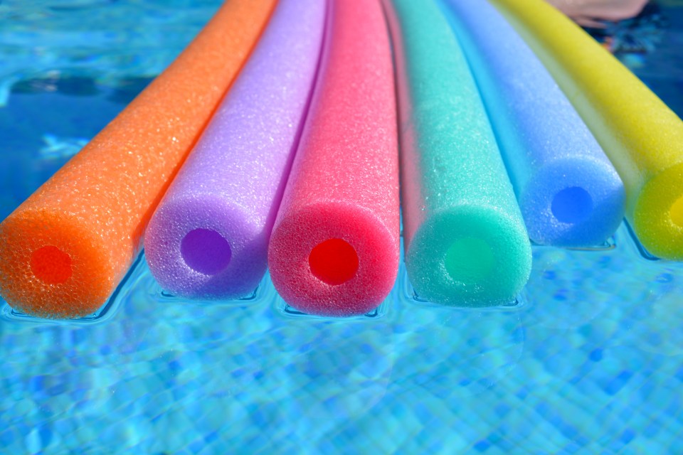 a bunch of colorful pool noodles are floating in the water