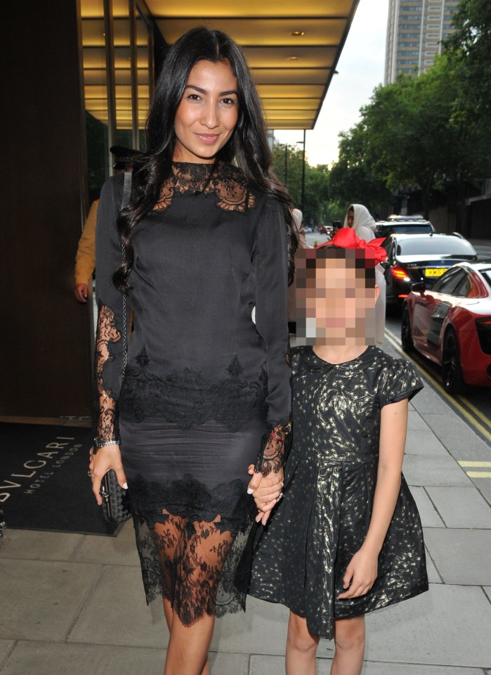 a woman in a black lace dress stands next to a little girl in a black dress