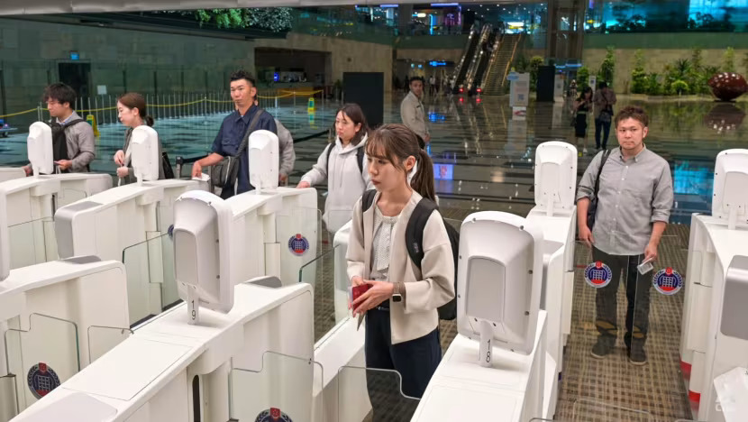 a woman stands in front of a machine that has a sticker on it that says ' passport control '