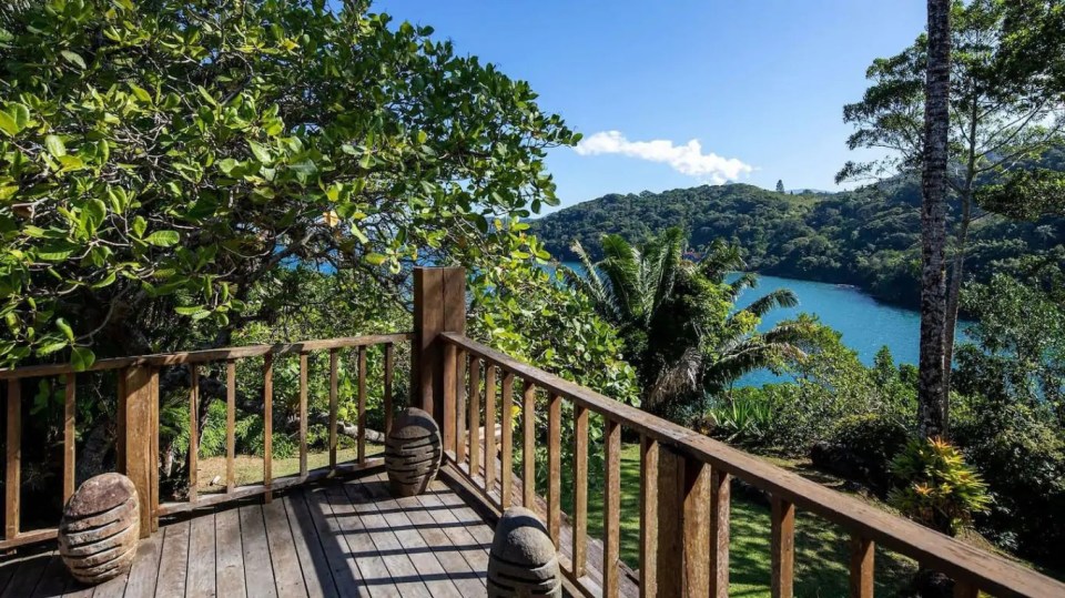 a wooden deck overlooking a body of water surrounded by trees