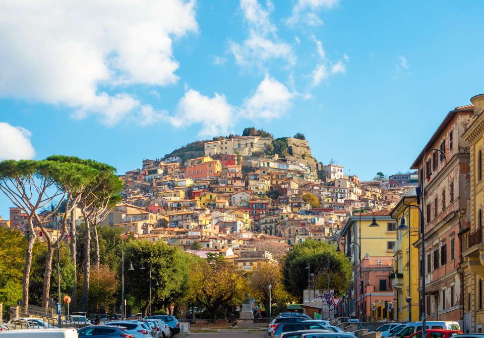 a row of buildings with a hill in the background