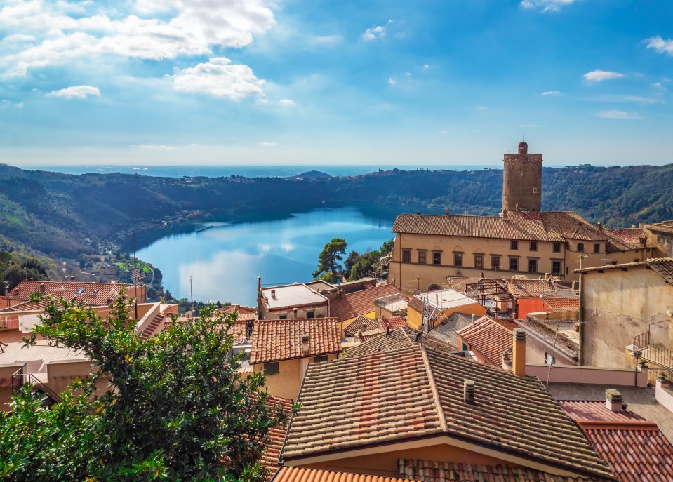 an aerial view of a city with a lake in the background