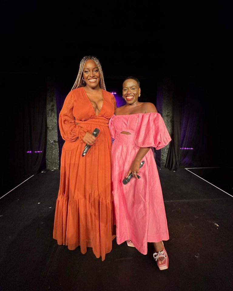 two women standing next to each other on a stage holding microphones