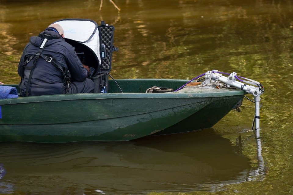 a man sits in a small green boat in the water