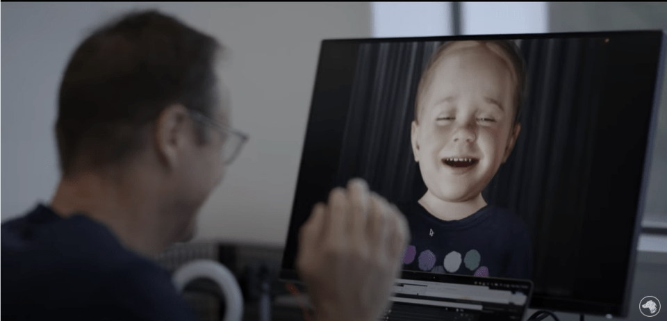 a man looks at a child on a computer screen