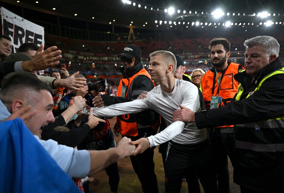 a man in a white shirt is shaking hands with a man in an orange vest with the word free on it