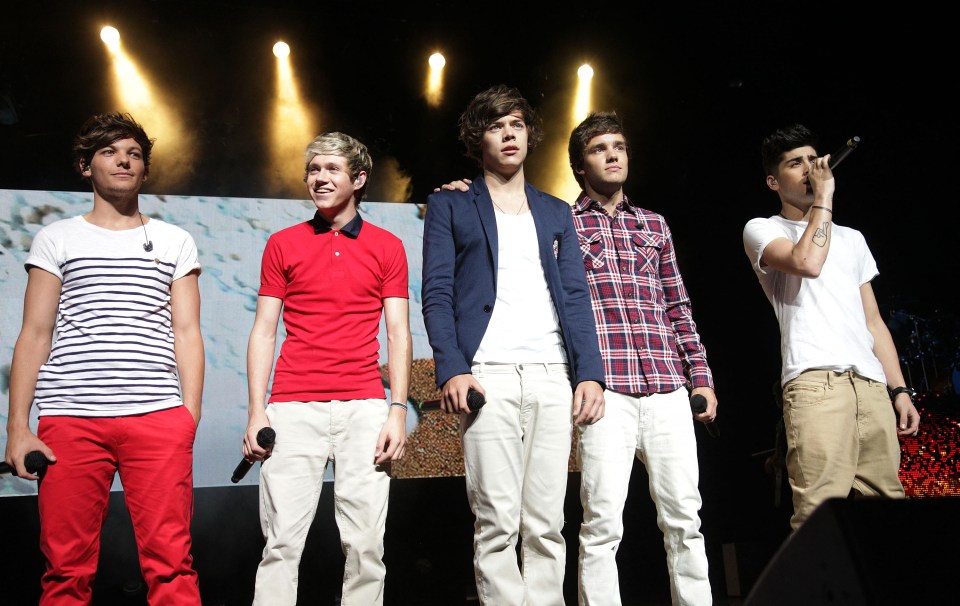 a group of young men standing on a stage with microphones