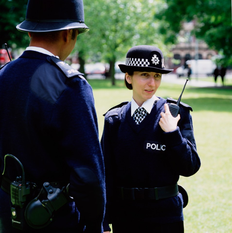 a woman in a police uniform is talking to a man