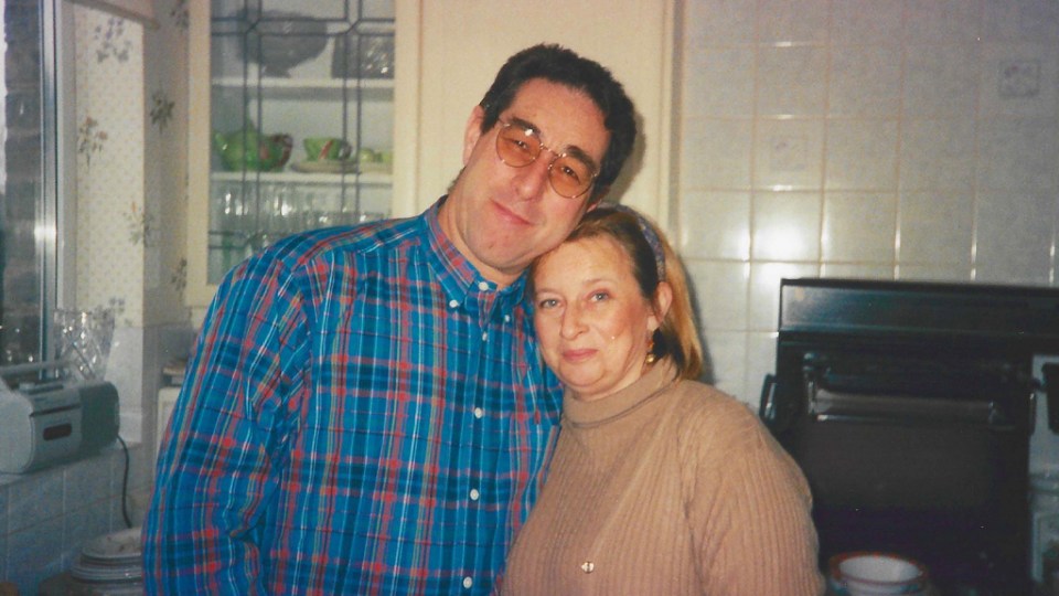 a man and woman posing for a picture in a kitchen