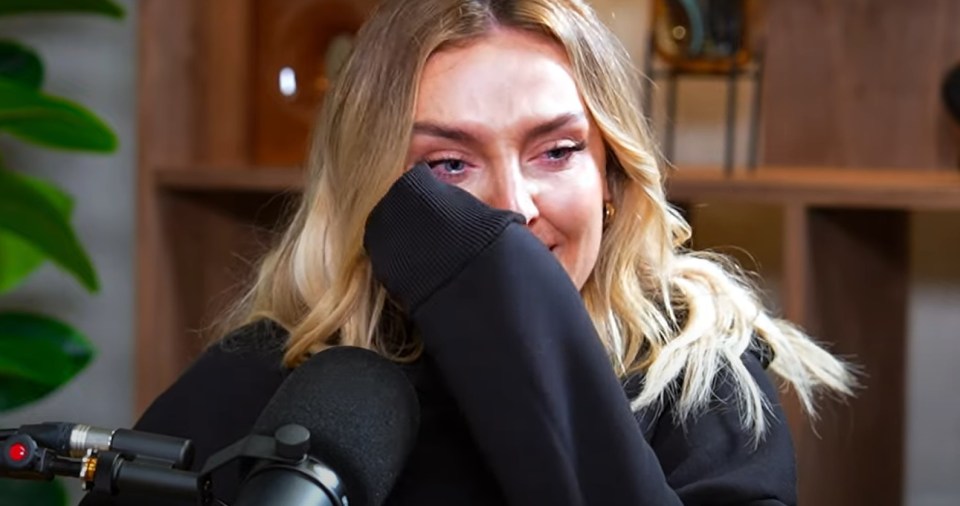 a woman is crying in front of a microphone