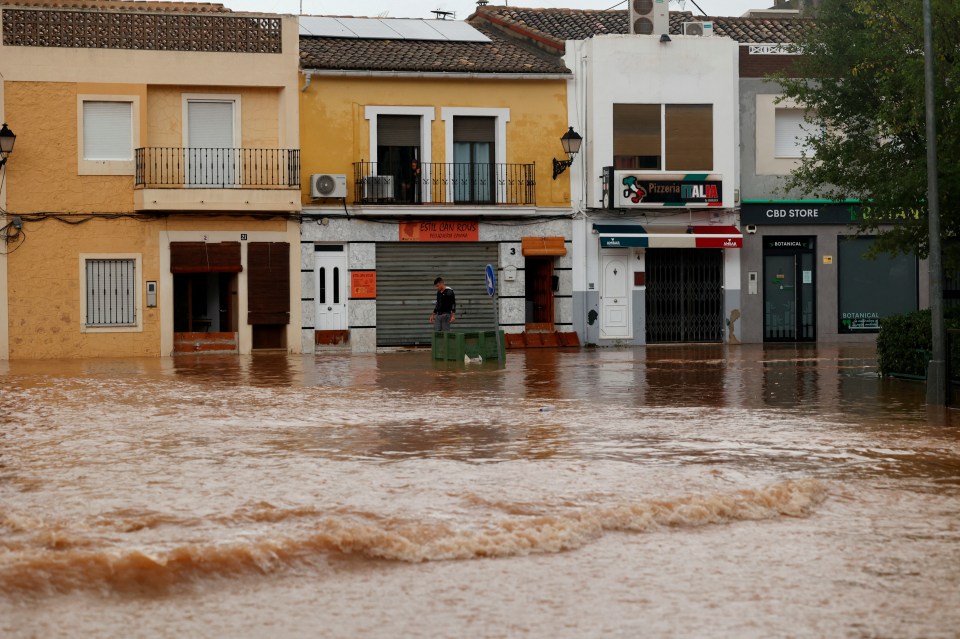 a flooded street with a cbd store in the background