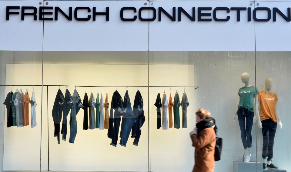 a woman walks past a french connection store