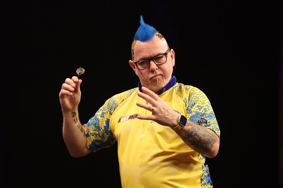 a man with a blue mohawk is holding a dart in his hand