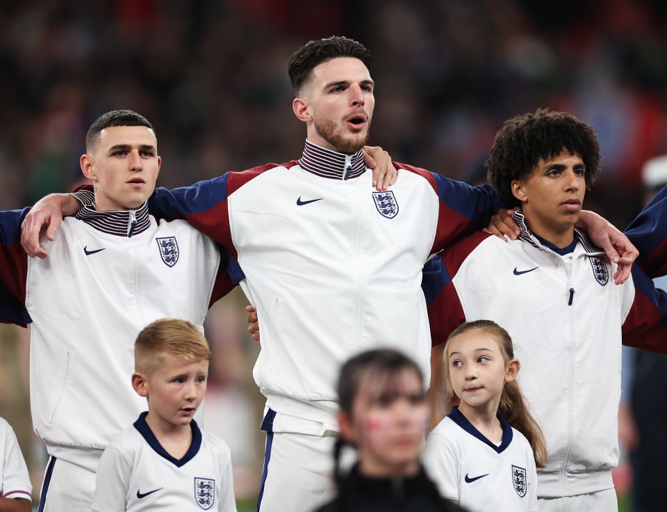 a group of soccer players wearing england jerseys stand together