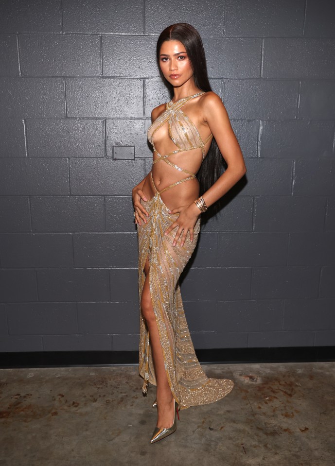 Zendaya shows off her killer body in a gold dress that highlights her toned abs