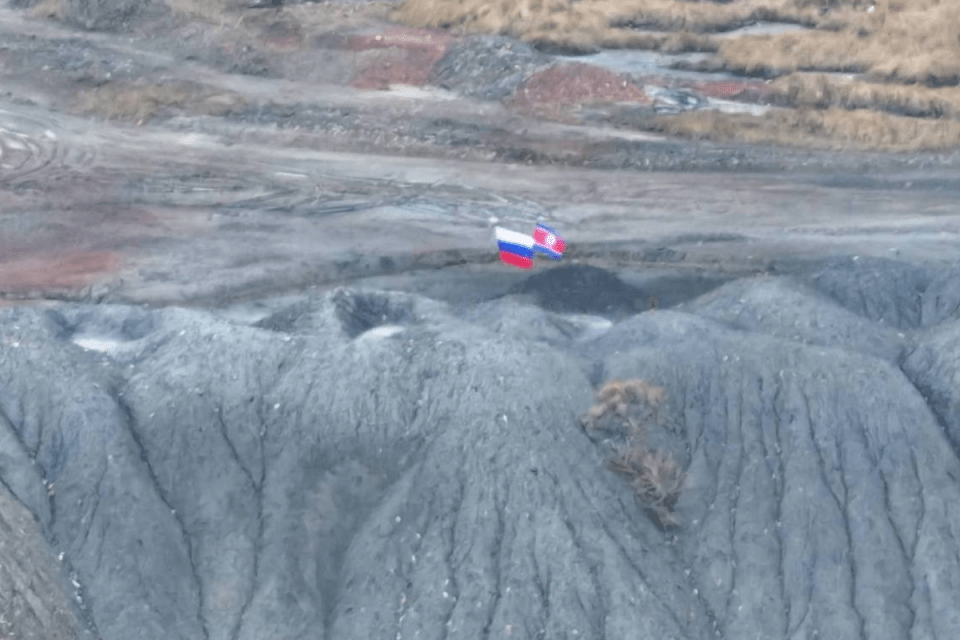 The blurry photo shows a North Korea flag flying alongside the Russian flag