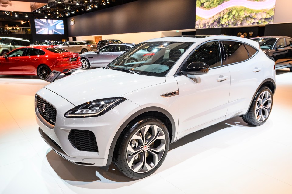 a white jaguar is on display at a car show