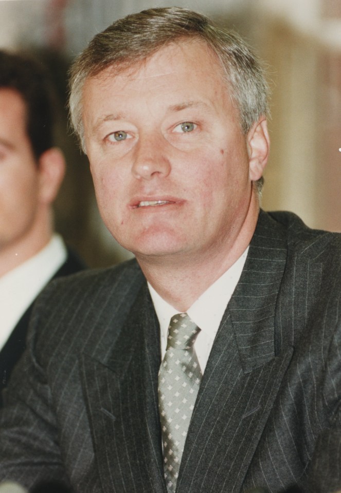 a man in a suit and tie looks at the camera