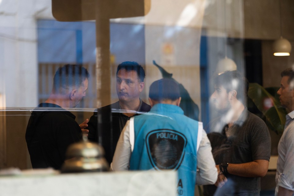 a man wearing a blue vest with the word policia on it