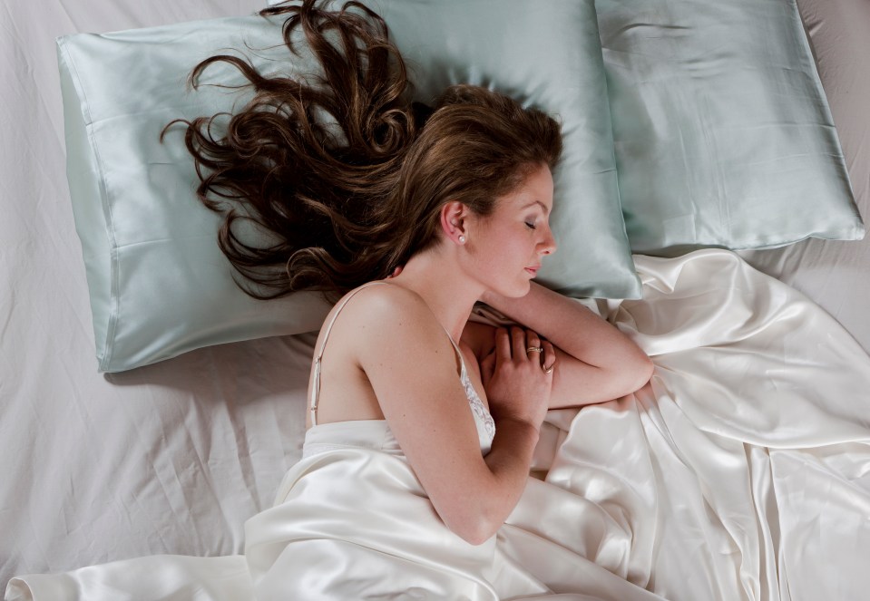 Portrait from high angle view of a cheerful young woman sleeping in her bed.