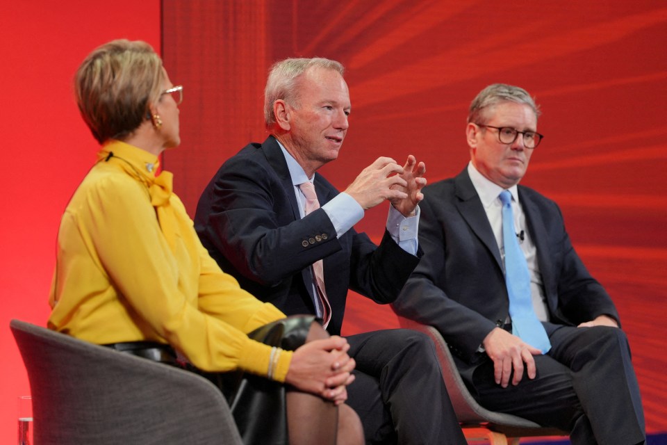 a man in a suit and tie is talking to two other men