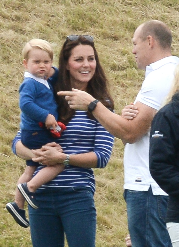 a woman in a striped shirt is holding a baby and pointing