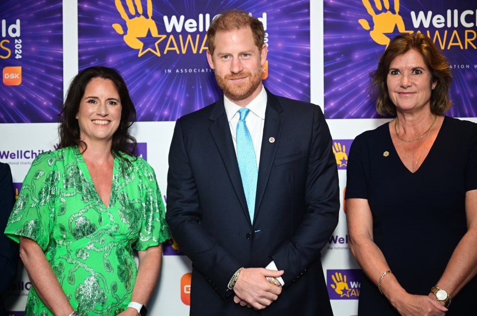 three people stand in front of a wall that says well awards