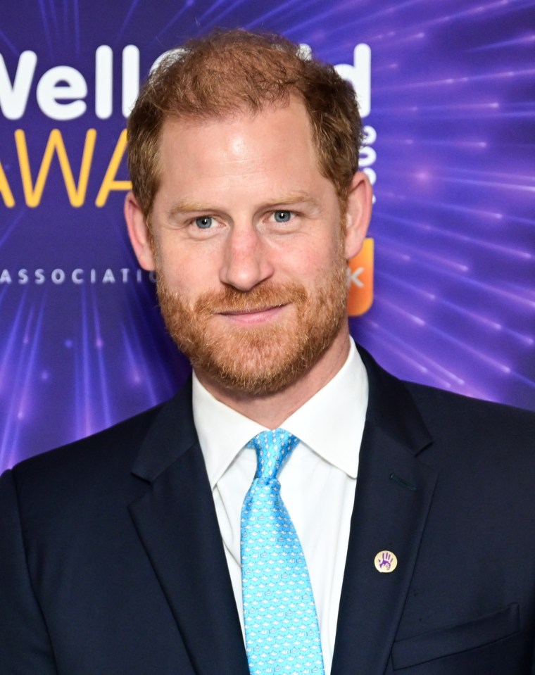 a man in a suit and tie stands in front of a sign that says wellesley awards