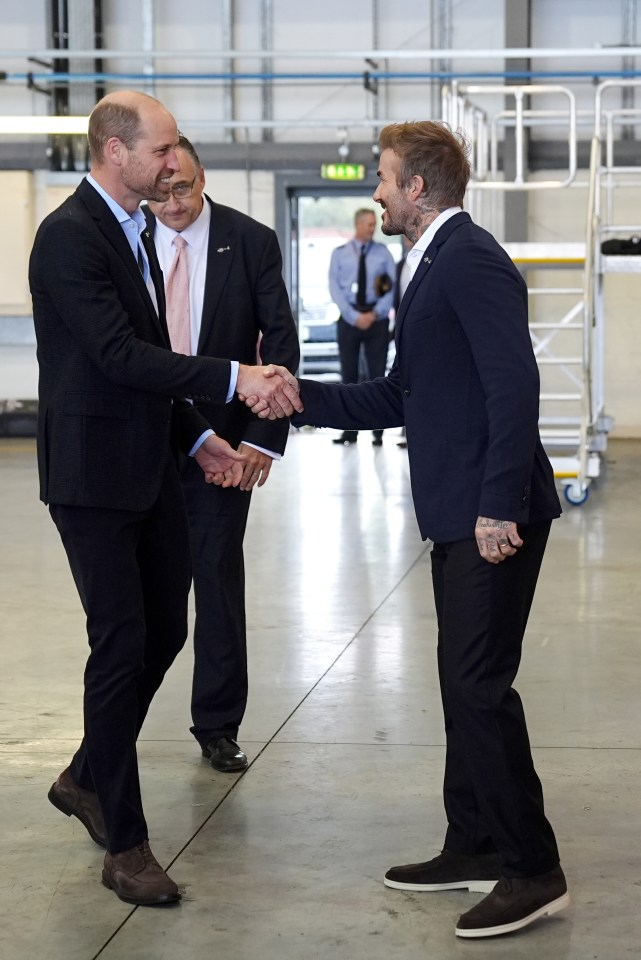 a man with a tattoo on his arm shakes hands with another man