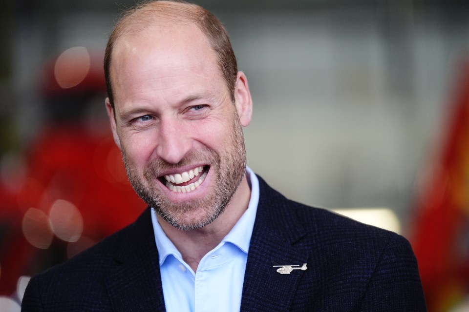 a man with a beard is smiling and wearing a pin on his jacket