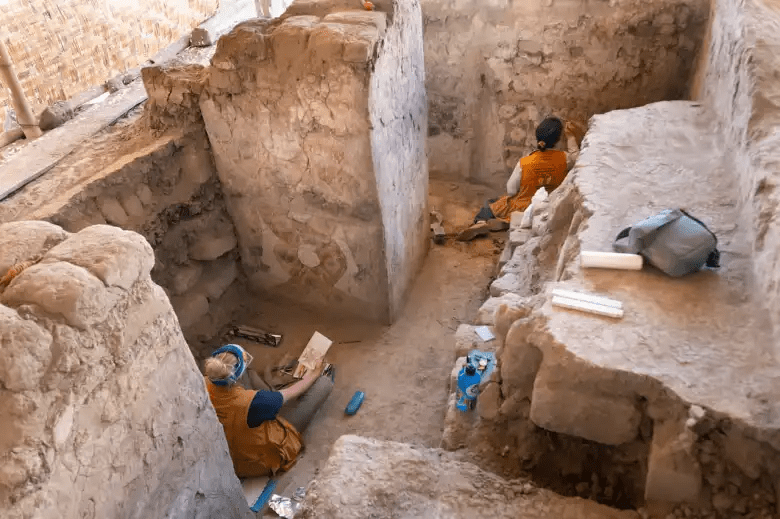 a man in a yellow shirt is sitting in the dirt